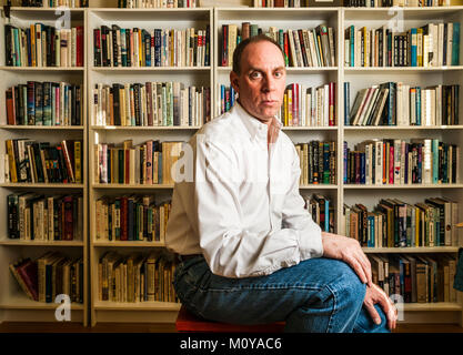 Das Porträt einer mittleren Alter Mann vor ein paar Regale mit Büchern gefüllt. Stockfoto