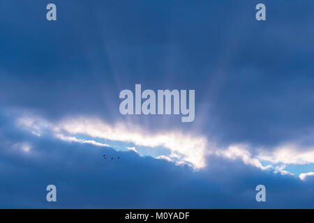 Lichtstrahlen, die durch die Wolken bersten Stockfoto