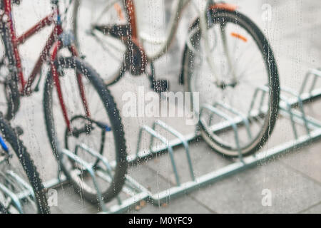 Blick auf abgestellte Fahrräder durch das Glas mit Wasser Stockfoto