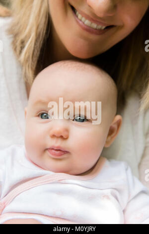 Lächelnd weißen Mutter Holding baby Tochter in Runde Stockfoto