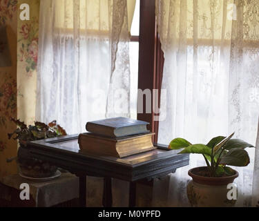 Antike Bücher auf einem Schreibtisch neben einem Fenster im Inneren des Thorpe House, viktorianisches Haus, erbaut 1886 und restauriert Stockfoto