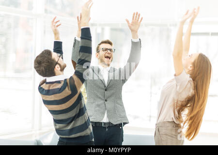 Konzept der Sieg - die jubelnde Business Team im Kreis stehend, Hände oben in Freude Erfolg. Stockfoto