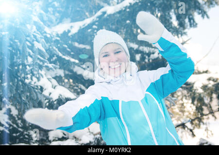 Schöne blonde lächelnde Mädchen in Sportkleidung glücklich Tänze in den Wäldern inmitten der Tannen. getönt. Stockfoto