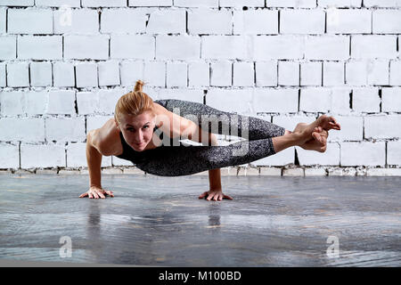 Junge attraktive lächelnde Frau mit Yoga. Sportliche hübsche Frau liebt Sport. Stockfoto