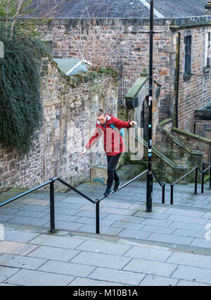 Grassmarket, Old Town, Edinburgh, Schottland, Großbritannien, 24. Januar 2018. Junger Mann balanciert Parkour auf Handlauf in Gassentreppen Stockfoto