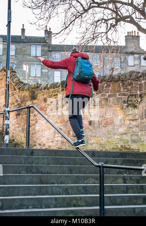 Grassmarket, Old Town, Edinburgh, Schottland, Großbritannien, 24. Januar 2018. Junger Mann balanciert Parkour auf Handlauf in Gassentreppen Stockfoto