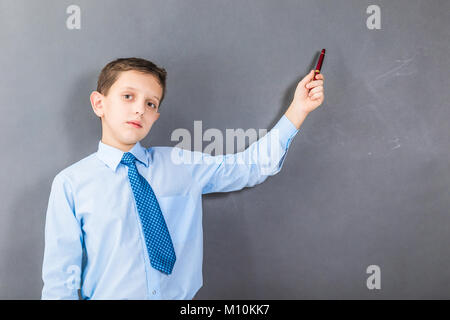 Zuversichtlich junge Student vor dem dunklen Hintergrund mit copy-Raum als Tafel Stockfoto