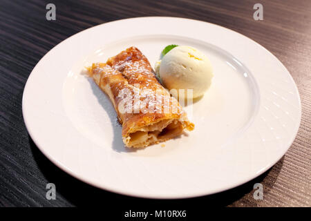 Apfelstrudel und Eis auf der Platte Stockfoto