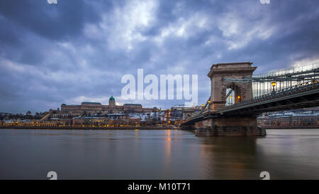 Budapest, Ungarn - Das berühmte Széchenyi Kettenbrücke über die Donau mit Buda Castle Royal Palace in der Dämmerung Stockfoto