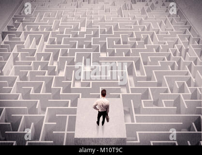 Ein verwirrter Geschäftsmann denken beim Stehen auf einer quadratischen Plattform über eine detaillierte Labyrinth Stockfoto