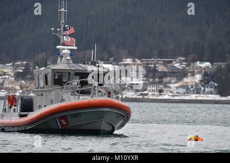 Mitglieder der Coast Guard Station Juneau an Bord eines 45-Fuß-antwort Boot - Medium, den Weg hin zu einem Dummy schwimmend im Wasser beim Leiten der Mann über Bord Ausbildung in Juneau, Alaska, Jan. 24, 2018. Station Juneau durchgeführt, um die Mann-über-Bord-Position Bohrer bei Frost zu erhalten neue Mitglieder boatcrew qualifiziert. U.S. Coast Guard Foto von Petty Officer 1st Class Jon-Paul Rios. Stockfoto