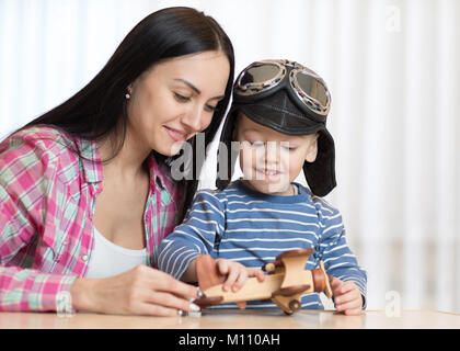 Mutter und Sohn spielen mit Holz- Ebenen. Stockfoto