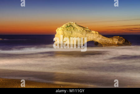 Die durchbohrte Gestein (Rocher Perce) am Miramar Beach in Biarritz, Frankreich, am Sonnenuntergang Stockfoto