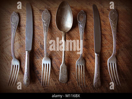 Löffel, Gabeln, Messer, Löffel auf einem Holztisch, selektiver Fokus und getönten Bild. Ansicht von oben. Stockfoto