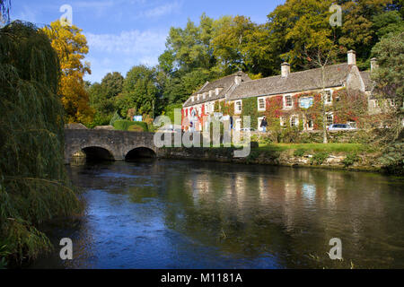 Bibury, Gloucestershire, Großbritannien - 7.. Oktober 2010: Klassische Frühherbstansicht der alten Brücke über den Fluss Coln in Bibury. Bibury wurde einst von William Morris (1834-96) als "das schönste Dorf in England" beschrieben. Stockfoto