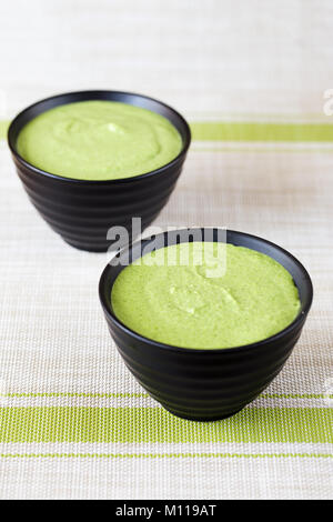 Zwei Portionen von broccoli Creme Suppe in die schwarzen Platten, Minimalismus Bild Stockfoto