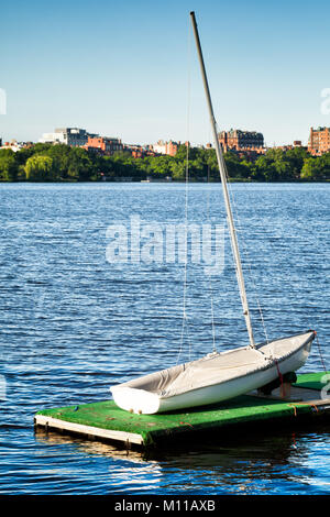 Boston Charles River kleinen Segelboot im Vordergrund. Beacon Hill historische Gebäude aus rotem Ziegel sind über das Wasser gesehen Stockfoto