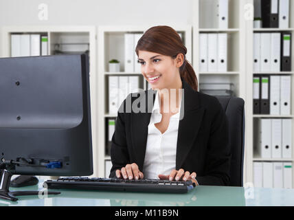 Lächelnden jungen Geschäftsfrau, Arbeiten am Computer im Büro Stockfoto