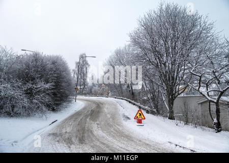 Im Bau Schild an einem Wintertag in einer Stadt. Schnee und gefrorenen Bäume und in der Nähe Häuser in einem Wohngebiet in Schweden Stockfoto