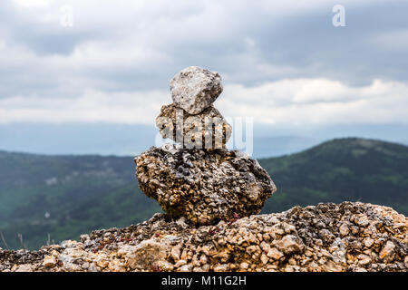 Schöne Steine im Gleichgewicht auf eine Betonwand überlagerte an der Seite der Straße. Calascio, Provinz L'Aquila, Abruzzen, Italien Stockfoto