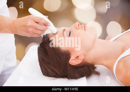 Nahaufnahme einer entspannten junge Frau, die sich einer Microdermabrasion Therapie auf der Stirn Stockfoto