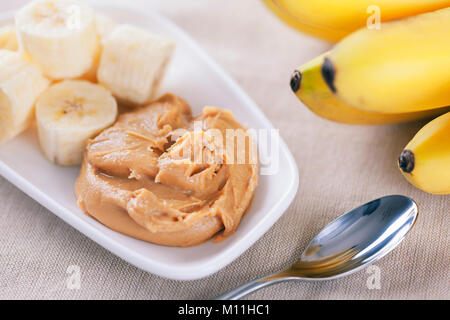 Am frühen Morgen gesund Bananen Frühstück. Selbstgemachte Erdnussbutter und Bananen. Selbstgemachte Erdnussbutter Zutaten: Erdnüsse (geröstet, ungesalzene, geschälte), Stockfoto