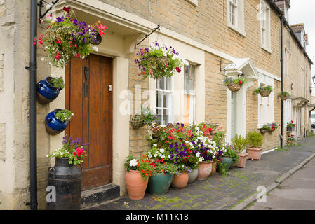 Blumenkörbe und Pflanzer schmücken ein Stadthaus in der Kirche Fuß Melksham Wiltshire England Großbritannien Stockfoto