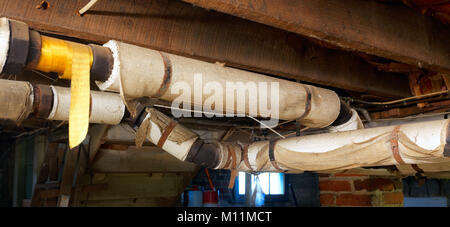 Keller Wasserleitungen mit Asbest Isolierung umwickelt. Stockfoto