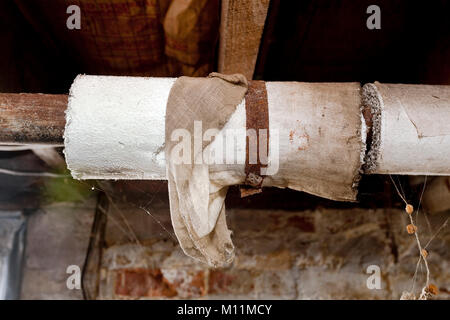 Keller Wasserleitungen mit Asbest Isolierung umwickelt. Stockfoto