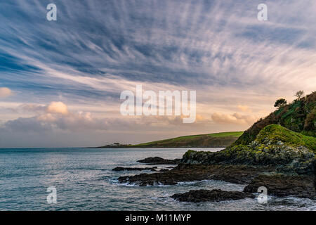 Blick auf Kapelle und Haus von der äußeren Hafen Mauer bei Mevagissey kurz vor einem kühlen Winter Sonnenuntergang. Stockfoto