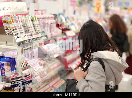 Frauen an der Make-up-Produkten und Kosmetika suchen Anzeige einer japanischen Schönheit store in Kyoto, Japan 2017 Stockfoto