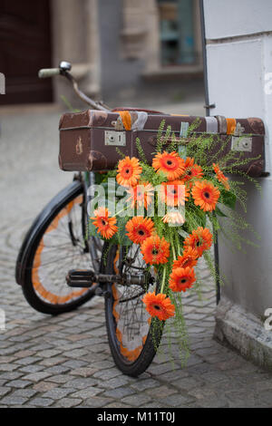 Retro Blumen Fahrrad mit orangen Blüten dekoriert, Gerbera Stockfoto