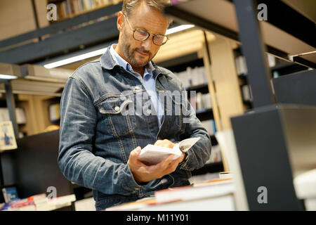 Der Mensch in der Buchhandlung auf der Suche nach neuen Bücher Stockfoto