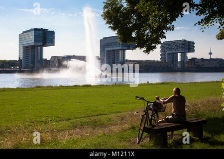 Deutschland, Köln, Feuerlöschboot duiring eine Löschübung am Rhein, Kran Häuser in Rheinau Hafen. Deutschland, Koeln, Feuerloeschboot bei Stockfoto