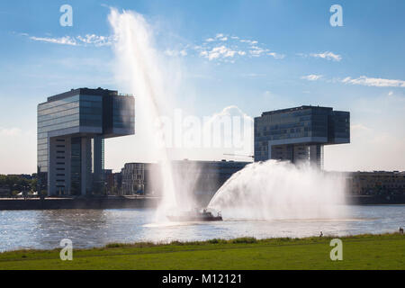 Deutschland, Köln, Feuerlöschboot duiring eine Löschübung am Rhein, Kran Häuser in Rheinau Hafen. Deutschland, Koeln, Feuerloeschboot bei Stockfoto