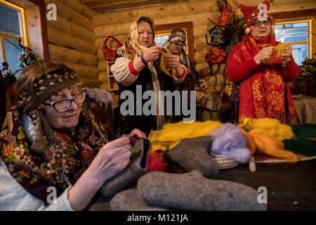 Eine Frau ist sticken eine Zeichnung auf Russische fühlte Stiefel in einem bäuerlichen Hütte in Moskau, Russland Stockfoto