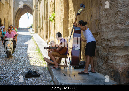 RHODES, Griechenland - AUGUST 2017: straßenmusikanten an der schmalen Straße von Rhodos Stadt auf der Insel Rhodos, Griechenland Stockfoto