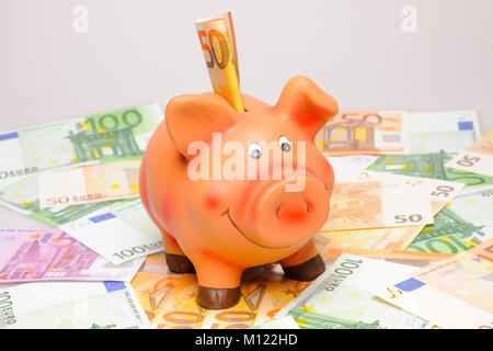 Rosa Sparschwein mit Euro-banknoten Stockfoto