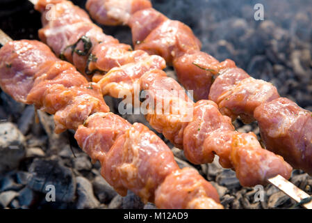 Marinierte Schaschlik vorbereiten auf ein Barbecue-Grill auf Holzkohle. Schaschlik oder Schaschlik in Osteuropa beliebt. Schaschlik aufgespießt Fleisch wurde ursprünglich Stockfoto