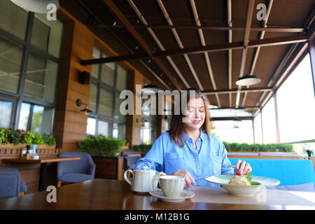 Europäische Mädchen trinken Kaffee im Restaurant und essen Kuchen. Stockfoto