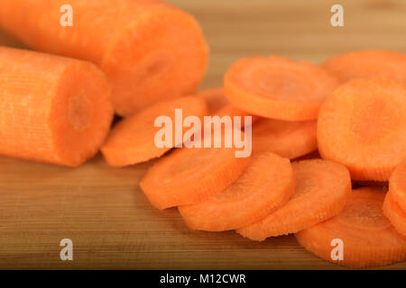 Nahaufnahme, Detail, runde Scheiben rohen Karotten, Zutat für gesunde Eintopf zubereitet, auf Holz Schneidebrett Stockfoto