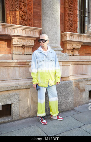 Mailand - Januar 14: Mann mit Gucci Sonnenbrillen und blauen, gelben und weißen Jeans Jacke und Hose vor dem MSGM fashion show, Mailand Fashion Week Straße Stockfoto