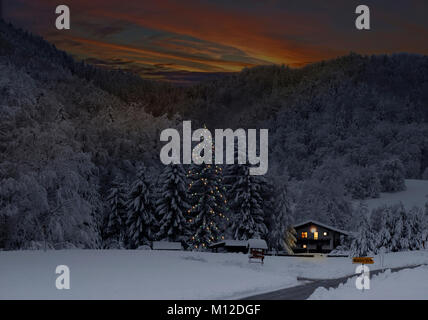 Ein Ferienhaus in der Dämmerung mit Weihnachtsbaum dekoriert. Savinjska Region; Stajerska (Steiermark) Slowenien Stockfoto