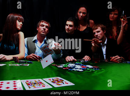 Stilvolle Mann im schwarzen Anzug falten zwei Karten im casino poker Las Vegas in Schwarz. Stockfoto