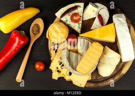 Verschiedene Arten von Käse mit Tomaten und Chili auf der Küche. Vorbereitung für gesunde Ernährung Stockfoto