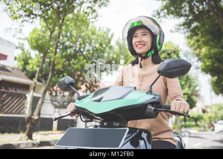 Portrait von Happy asiatische Frau reitet auf Motorrad in der Stadt. Stockfoto