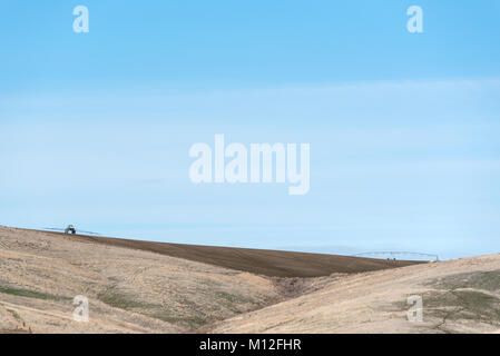 Landwirt mit einem Traktor Feldspritze auf ein Feld im östlichen Oregon. Stockfoto