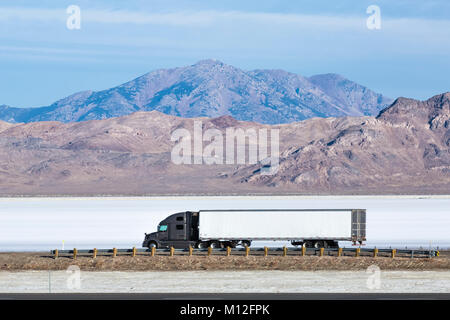 Semi Truck west Reisen auf der I-80 in der Bonneville Salt Flats, gesehen von der Wendover Salt Flats Rastplatz, Utah, USA Stockfoto