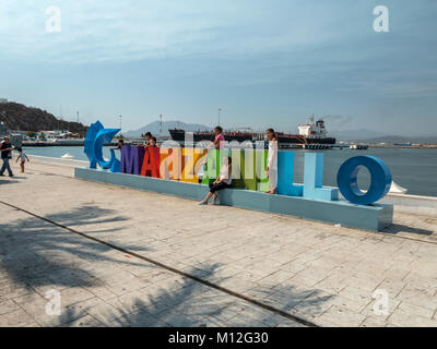 Eine Familie posieren für Fotos an der Manzanillo bunte Touristische Schild an der Waterfront von Manzanillo Colima Mexiko Stockfoto