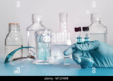 Zwei flüssige Proben in Kunststoff-Phiolen in der Hand der Wissenschaftlerin Stockfoto